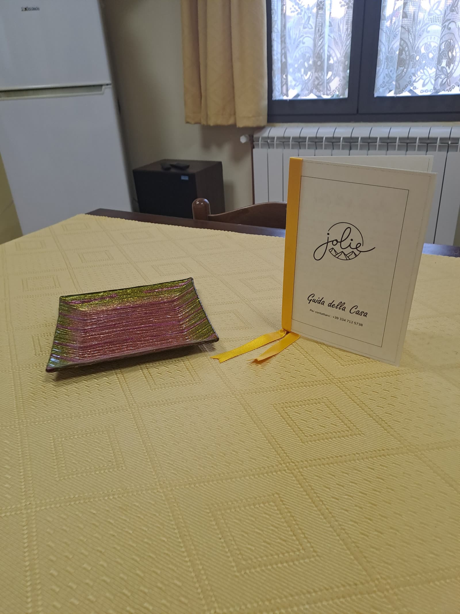 La guida della casa stampata, con il logo Jolie in copertina, appoggiata sul tavolo da pranzo