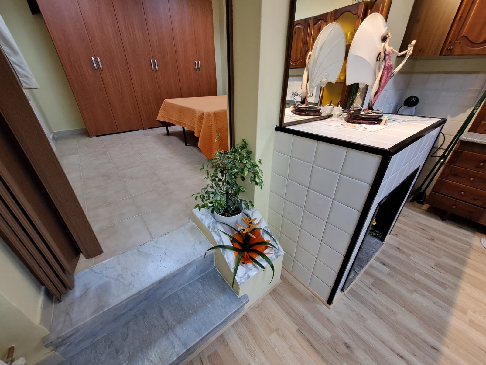 Ingresso della casa con camino rivestito in ceramica e disimpegno verso le camere
