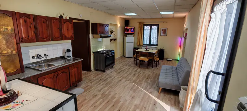 Il salone open space della casa Jolie con cucina attrezzata, divano letto alla francese e zona pranzo